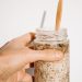 a person holding a jar of food with a wooden spoon in it