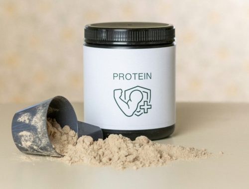 a jar of protein powder next to a scoop of powder